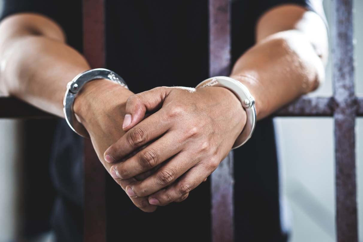 Prisoner in Handcuffs Inside a Cell